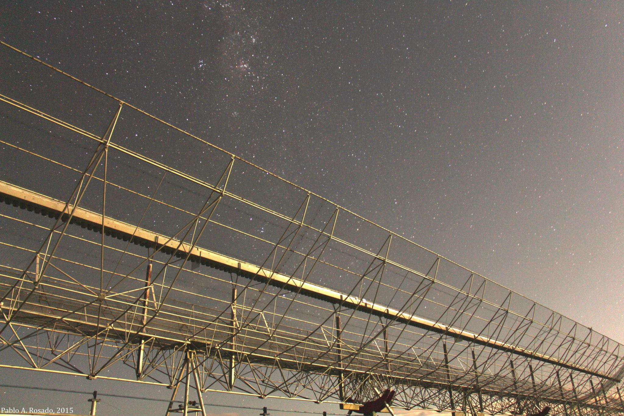 The Molonglo radio telescope at night, its long steel structure under the Milky Way