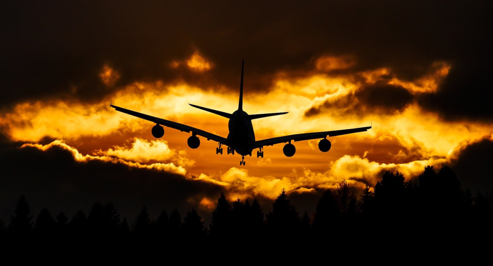 Airplane flying among clouds in the sunset